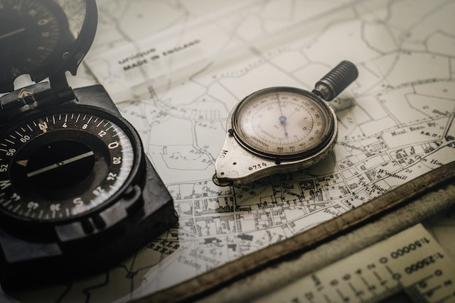 map on a desk with two compasses